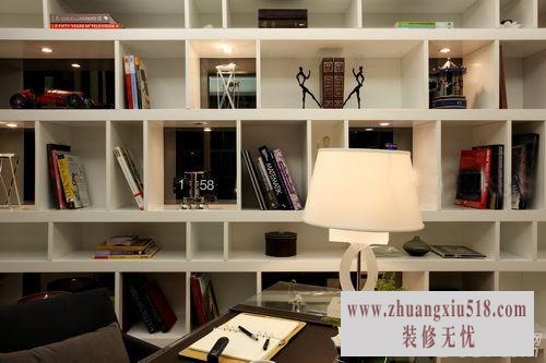 地下书房不需要过多的点缀,不规则方格组合成整面墙的书架,已经营造出了墙面时尚感。此外,每一个白色的格子的配饰内容都有着关于哲理、艺术和生活的故事。而与白色对立的深色桌椅,则以其厚重的沉稳,烘托出了空间沉静的气质。